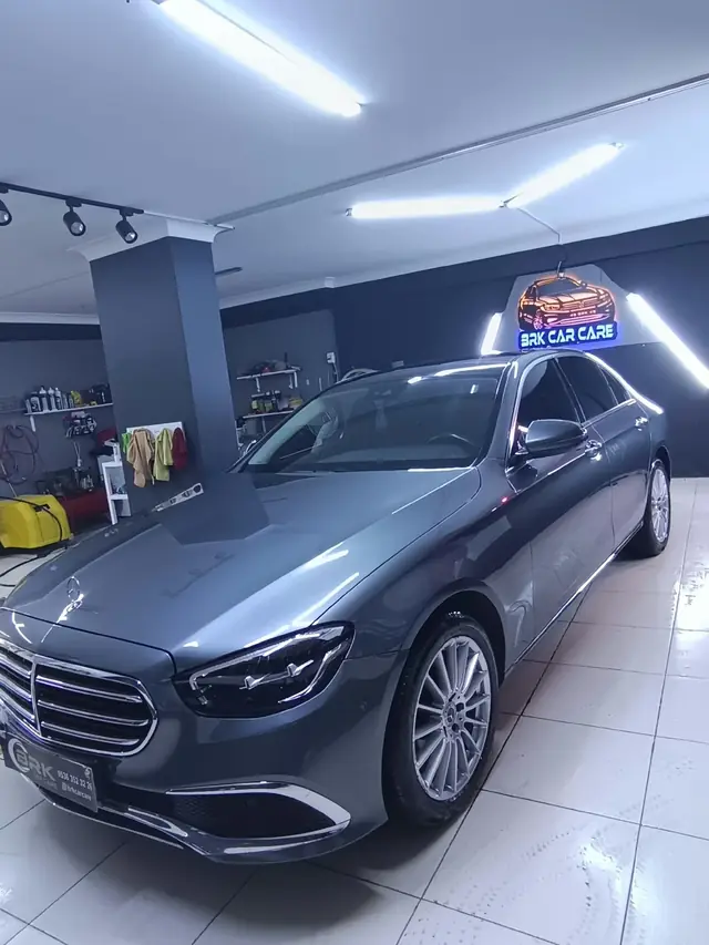 BRK Car Care stüdyosunda neon tabelanın önünde gri Mercedes E Serisi